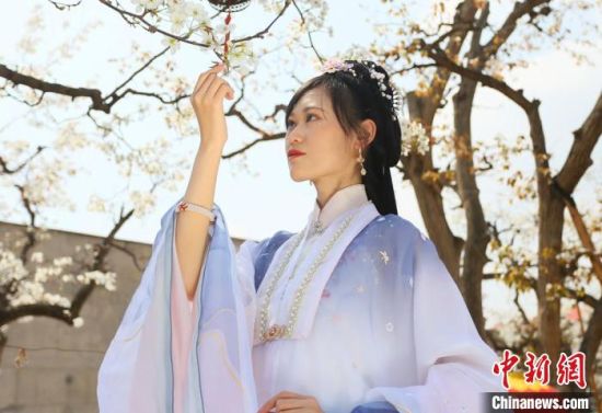 圖為蘭州青年身穿漢服在百年梨園賞景?！「哒?攝