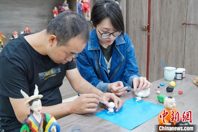 <a target='_blank'  data-cke-saved- >中新社</a>記者(右)現(xiàn)場(chǎng)體驗(yàn)面塑制作過(guò)程?！￡悹?zhēng)強(qiáng) 攝
