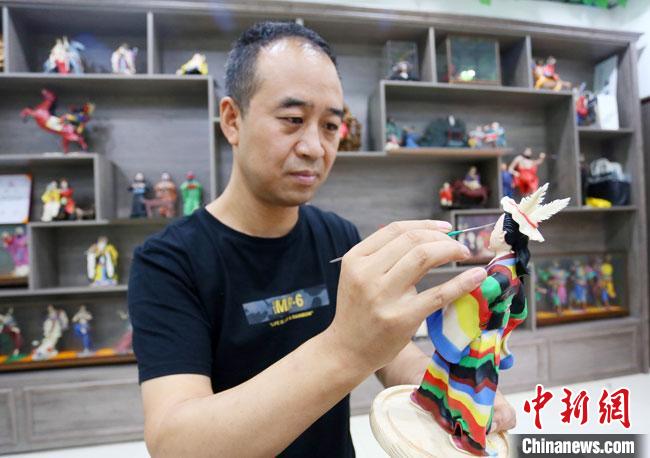 圖為安秋平正在創(chuàng)作代表隴南文縣民俗的《白馬人》作品。　高展 攝