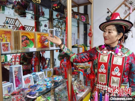 圖為身著民族服飾的隴原巧手展示手工藝品。(資料圖) 徐雪 攝