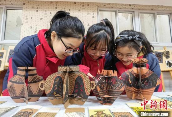 圖為學(xué)生用紙創(chuàng)作的立體彩陶?！⒂裉?攝