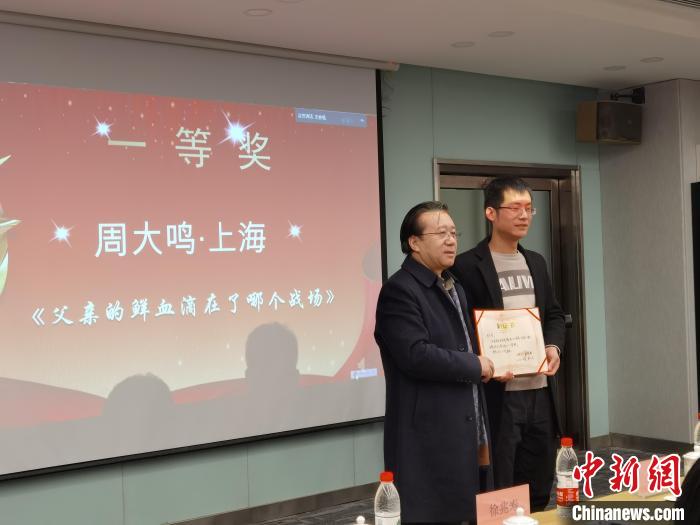 圖為作家、西北師范大學(xué)新聞與傳媒學(xué)院院長徐兆壽頒發(fā)一等獎證書，代領(lǐng)獎?wù)呱吓_領(lǐng)獎。　楊娜 攝