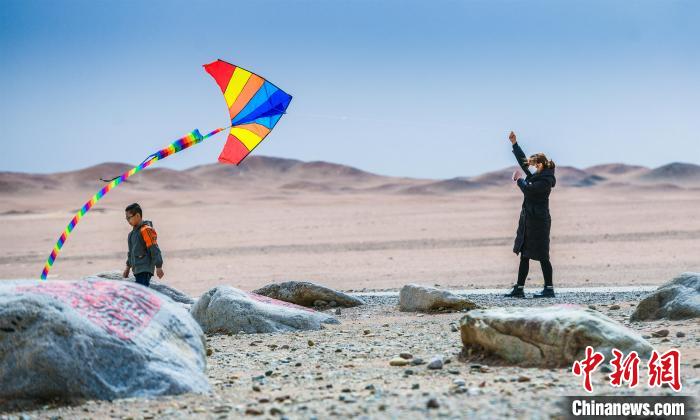 圖為市民正在陽關(guān)景區(qū)放風(fēng)箏。　王斌銀 攝