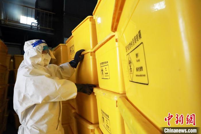 圖為工作人員搬運醫(yī)療廢物專用周轉(zhuǎn)箱。　魏建軍 攝