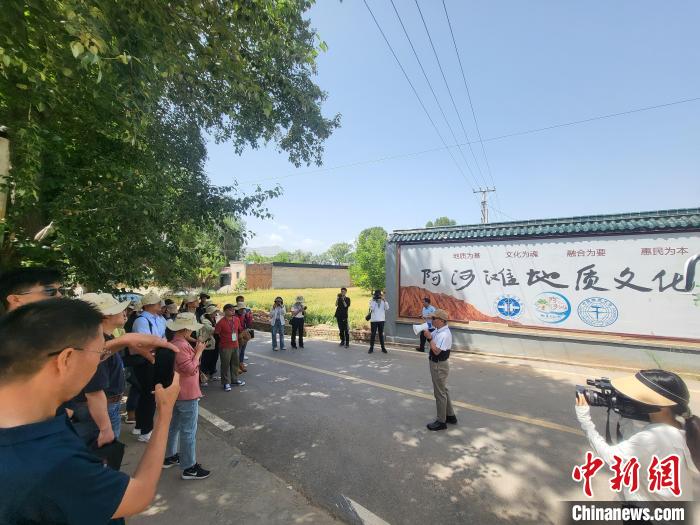 圖為中國地質(zhì)大學(xué)(北京)教授張緒教介紹村落情況?！『衍?攝