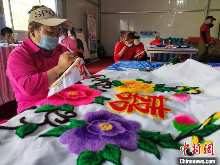 圖為婦女制作青繡?！?zhí)砀?攝