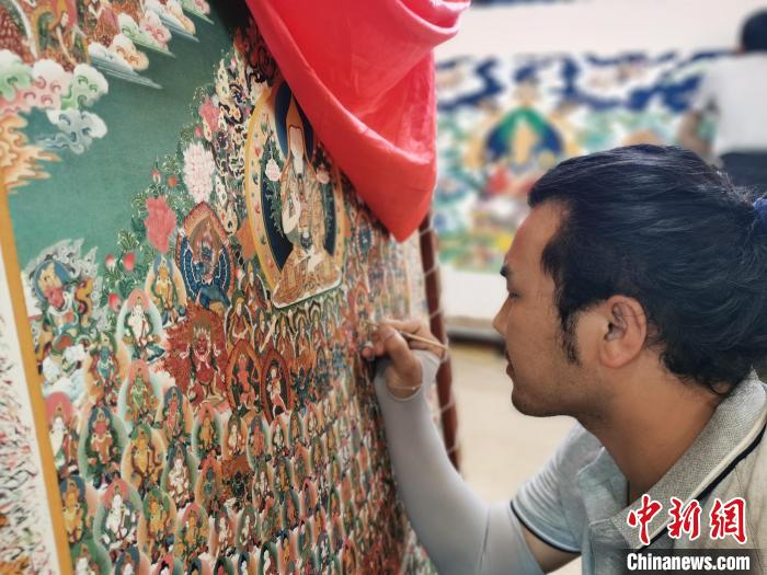 圖為更登才讓的徒弟繪畫(huà)唐卡。　張?zhí)砀?攝