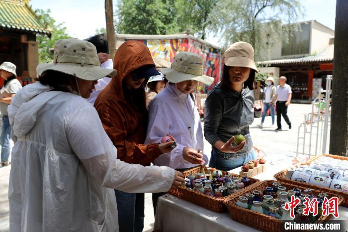 圖為民眾挑選手工藝產(chǎn)品?！⊙Φ?攝