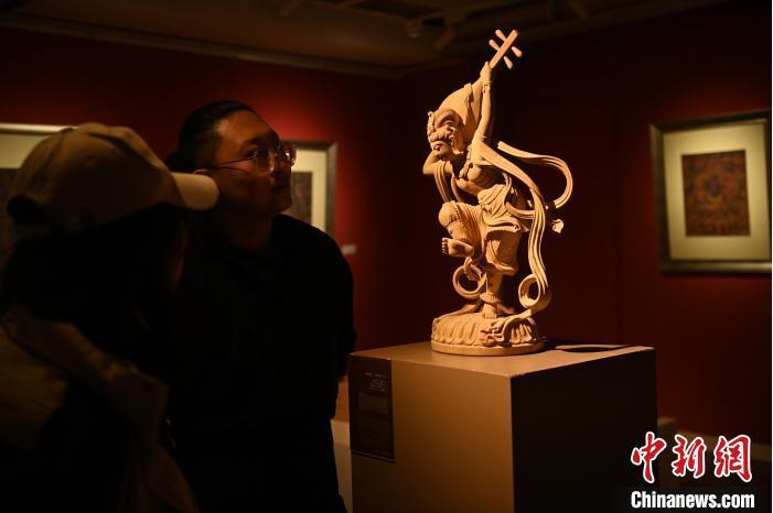 圖為季茂杰向參觀者介紹自己創(chuàng)作敦煌木雕的過程。李亞龍 攝</p>
<p>