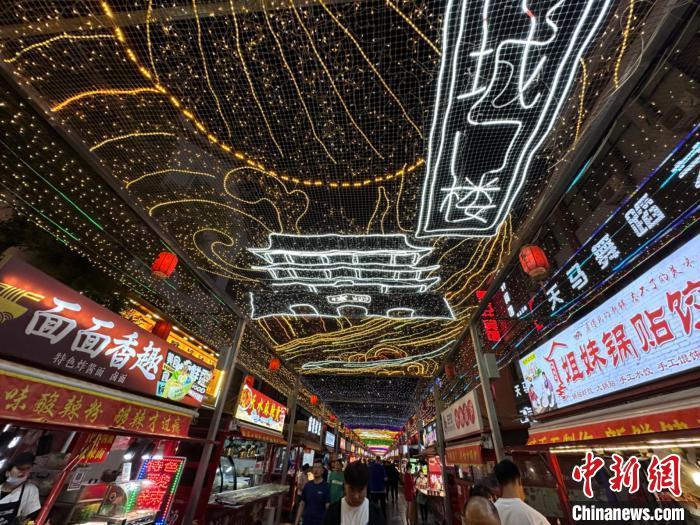 圖為明清街夜市燈光點(diǎn)亮具有武威文化元素的“涼州古城門”彩燈?！〈魑牟?攝</p><p>