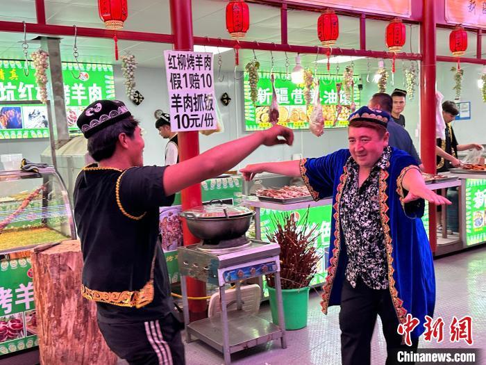 圖為餐飲經(jīng)營者在“西涼不夜城”跳起舞蹈引客?！〈魑牟?攝</p><p>