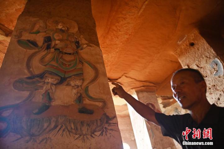 7月15日，甘肅省平?jīng)鍪袥艽h百里石窟長廊羅漢洞石窟內(nèi)，該窟文保員郭建平介紹窟內(nèi)石刻彩繪壁畫。郭建平家中三代人曾自發(fā)保護(hù)羅漢洞石窟。羅漢洞石窟遺存40余個窟龕，以北魏至清代風(fēng)格為主。中新社記者 李亞龍 攝</p>
<p>