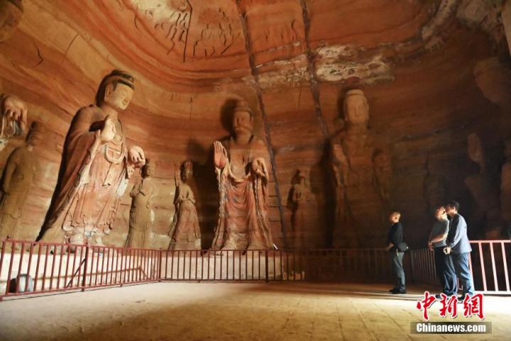 7月15日，游人參觀甘肅省平?jīng)鍪袥艽h百里石窟長廊中的南石窟寺1號窟。百里石窟長廊位于涇川縣境內(nèi)，由512個石窟、5眼窟中石井組成，現(xiàn)存王母宮石窟、鳳凰山石窟、南石窟寺、丈八寺石窟、羅漢洞石窟、太山寺石窟等規(guī)模較大的石窟群，還有數(shù)量眾多的小石窟群。南石窟寺開鑿于北魏永平三年，其中1號窟屬于大型七佛窟，七佛高達(dá)6米。中新社記者 李亞龍 攝