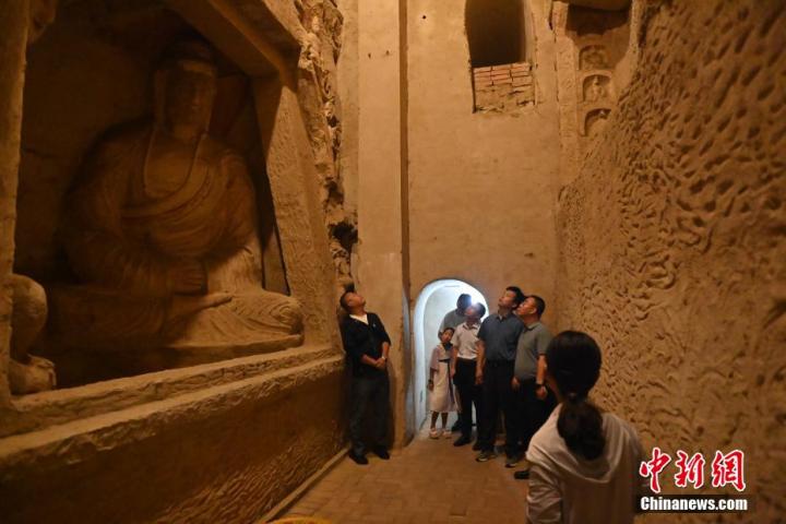 7月15日，游人參觀甘肅省平?jīng)鍪袥艽h百里石窟長廊中的王母宮石窟。百里石窟長廊位于涇川縣境內(nèi)，由512個石窟、5眼窟中石井組成，現(xiàn)存王母宮石窟、鳳凰山石窟、南石窟寺、丈八寺石窟、羅漢洞石窟、太山寺石窟等規(guī)模較大的石窟群，還有數(shù)量眾多的小石窟群。王母宮石窟又名千佛洞，該窟設(shè)計宏大，造像生動，窟內(nèi)擁有造像數(shù)百尊，是較為珍貴的佛教文化歷史遺存。中新社記者 李亞龍 攝</p>
<p>