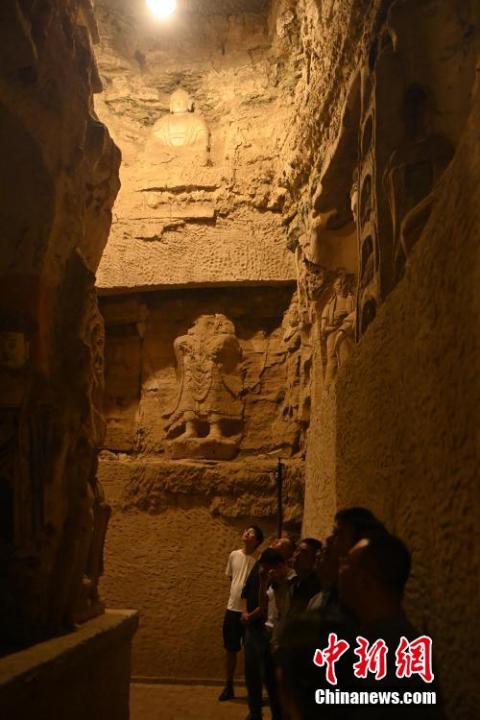 7月15日，游人參觀甘肅省平?jīng)鍪袥艽h百里石窟長廊中的王母宮石窟。百里石窟長廊位于涇川縣境內(nèi)，由512個石窟、5眼窟中石井組成，現(xiàn)存王母宮石窟、鳳凰山石窟、南石窟寺、丈八寺石窟、羅漢洞石窟、太山寺石窟等規(guī)模較大的石窟群，還有數(shù)量眾多的小石窟群。王母宮石窟又名千佛洞，該窟設(shè)計宏大，造像生動，窟內(nèi)擁有造像數(shù)百尊，是較為珍貴的佛教文化遺存。中新社記者 李亞龍 攝</p>
<p>