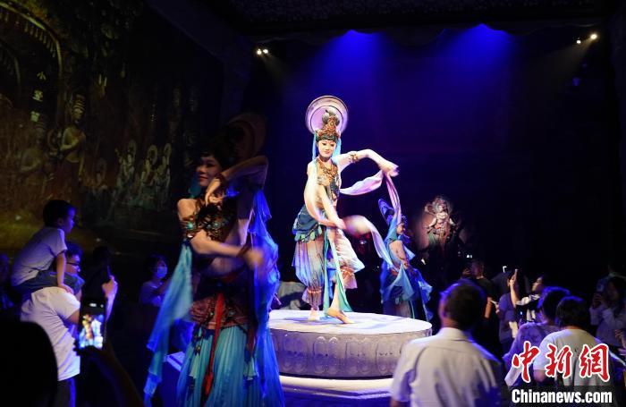 《樂動敦煌》是全球首部洞窟式沉浸體驗劇，利用真人與數(shù)字影像虛實交換實現(xiàn)沉浸式體驗。圖為2023年8月28日晚，《樂動敦煌》演出。(資料圖)中新社記者 毛建軍 攝