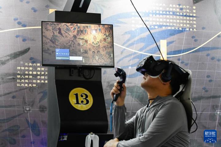 7月22日，游客借助VR設(shè)備沉浸式游覽莫高窟第285窟虛擬場(chǎng)景。新華社記者 郎兵兵 攝